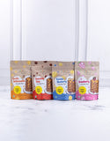 Four packages of pancake mix with different flavors on a white background